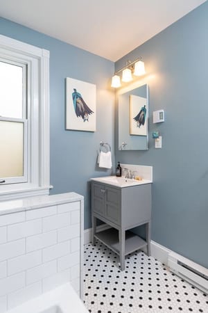 A Wonderful Grey Accented Bathroom Featuring Black and White Tile and Grey Sink