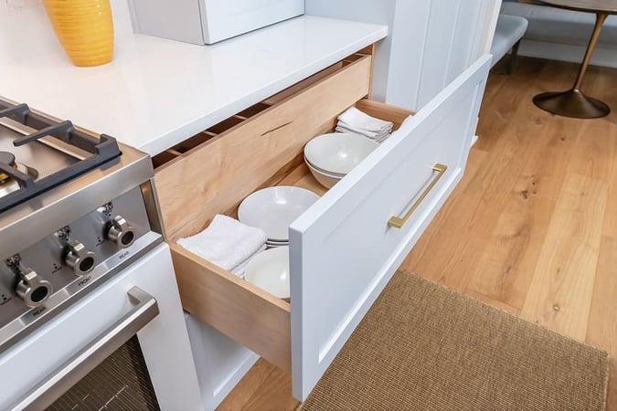 Drawer filled with white plates and bowl in transitional kitchen by Bellweather Design-Build in Philly