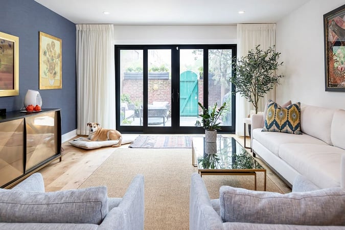 Transitional living room with blue accent walla and black accents by Bellweather Design-Build in Philadelphia